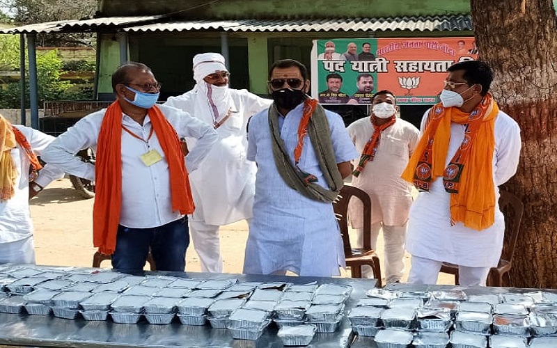 BJP workers distribute lunch packets to migrant workers on foot